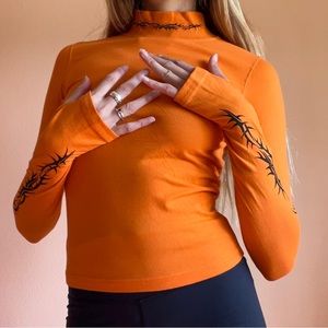 SOLD Wasted Paris Orange Turtleneck Thumb Holes Black Graphic Top